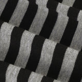 Asymetrická černobílá pruhovaná halenka s jedním ramenem a dlouhým rukávem, přiléhavý střih