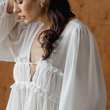 Bílá šifonová halenka s volánky a výstřihem do V s zavazováním