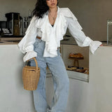 Bílá halenka s volánky, výstřihem do V a rozšířenými rukávy